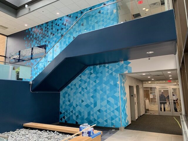 A blue wall with a staircase in the middle of it