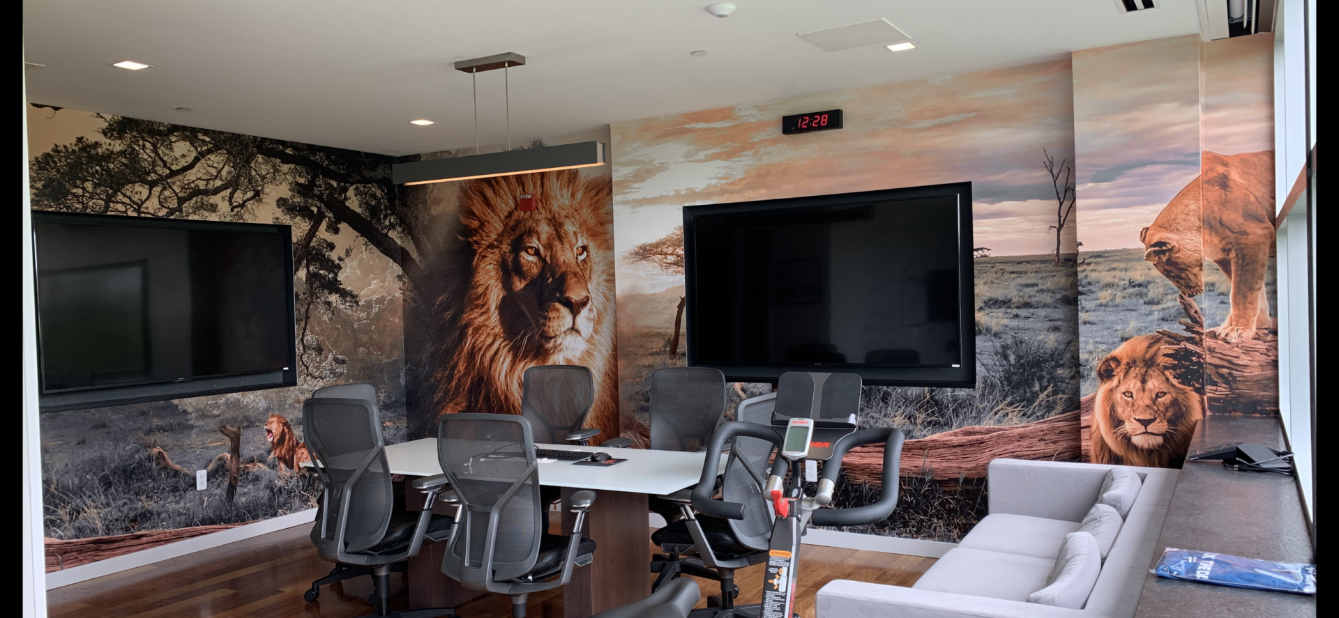 A room with a large screen tv and a wall mural.
